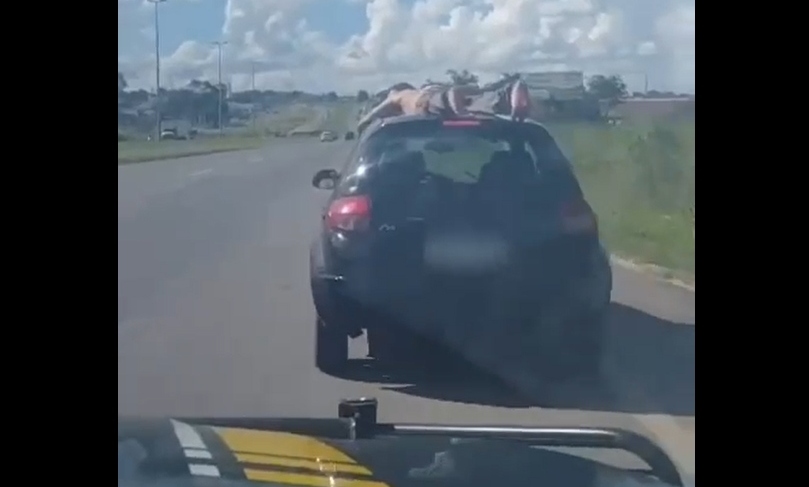 Homem bêbado é preso na rodovia BR-153/GO após ser flagrado sobre o teto de um carro de passeio, em Goiânia (GO).
